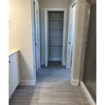 bathroom with vanity on left and shower on right and a view of closet directly ahead