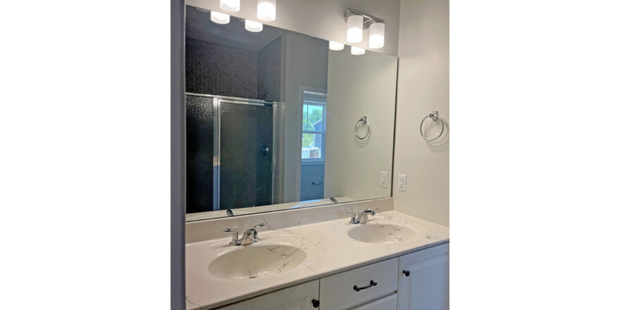 two sinks under a large mirror and vanity