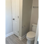 a white toilet sitting next to a bathroom closet