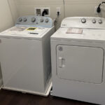 two washers and dryer in a small room