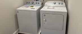 two washers and dryer in a small room