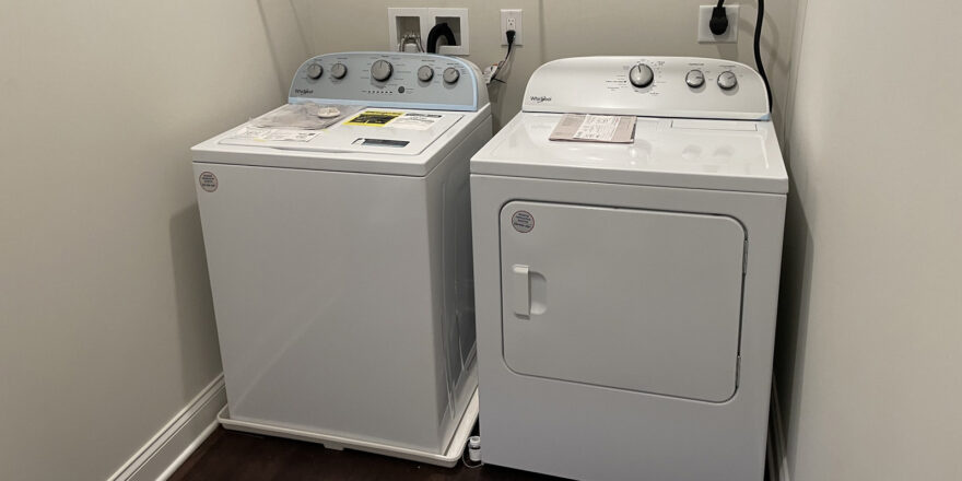 two washers and dryer in a small room