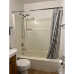 a white bath tub sitting next to a toilet