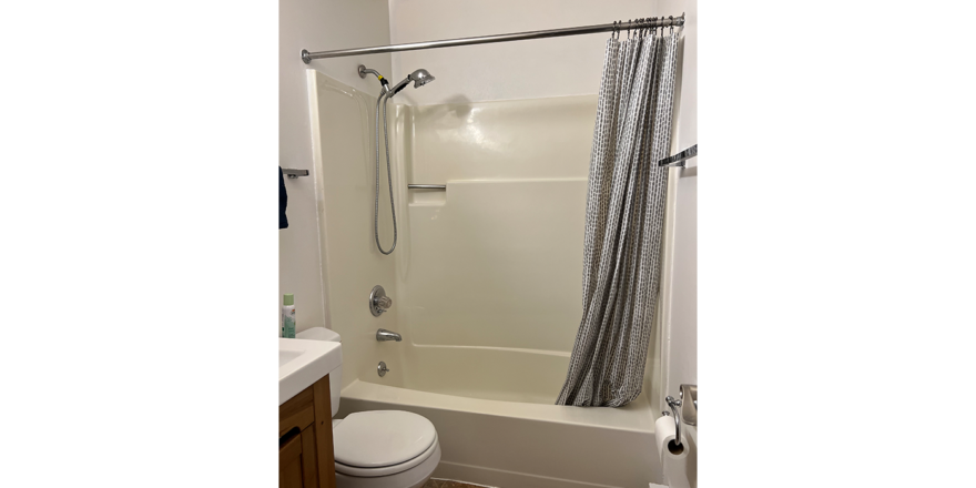 a white bath tub sitting next to a toilet