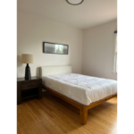 a bed sitting in a bedroom on top of a hard wood floor