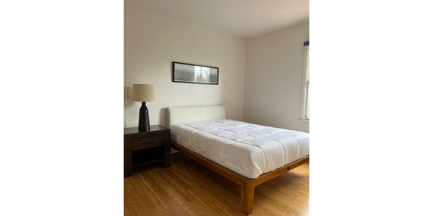 a bed sitting in a bedroom on top of a hard wood floor