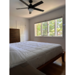 a bedroom with a bed, window, and ceiling fan