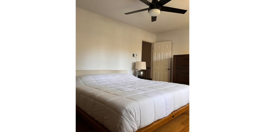 a bedroom with a bed and ceiling fan