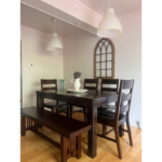 a dining room table with chairs and a bench
