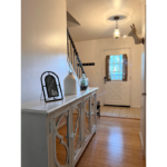 a hallway with a white cabinet and wooden floors