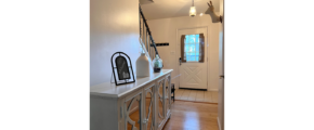 a hallway with a white cabinet and wooden floors