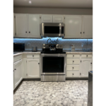 a kitchen with white cabinets and stainless steel appliances