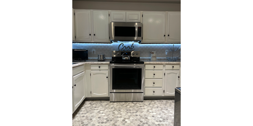 a kitchen with white cabinets and stainless steel appliances