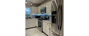 a kitchen with stainless steel appliances and white cabinets