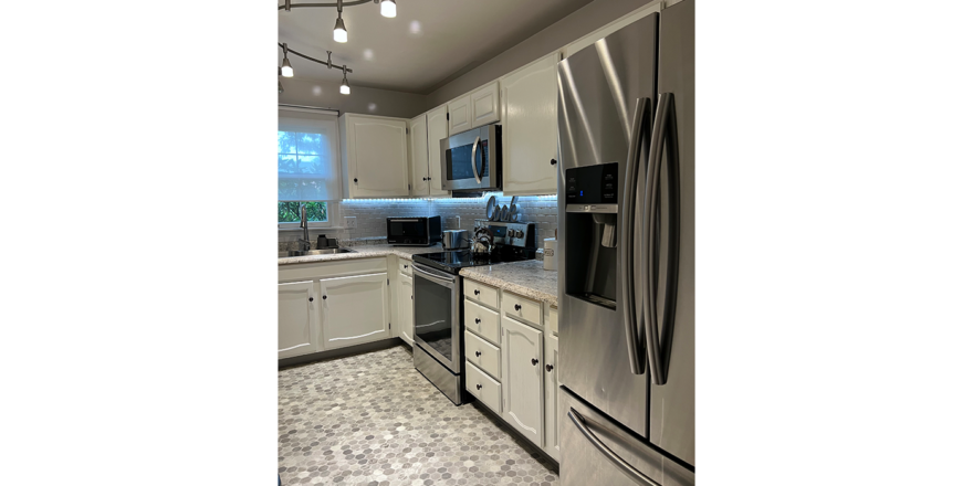 a kitchen with stainless steel appliances and white cabinets