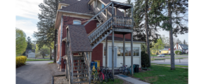 a red house with a balcony and stairs