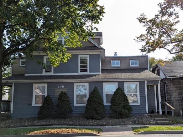 a gray house with trees in front of it