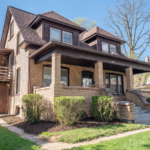 a brown brick house with two story windows