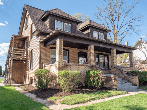 a brown brick house with two story windows