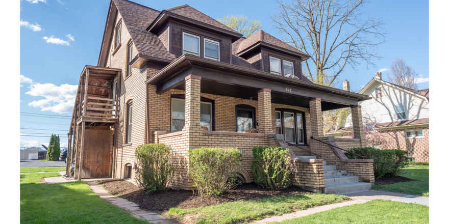 a brown brick house with two story windows