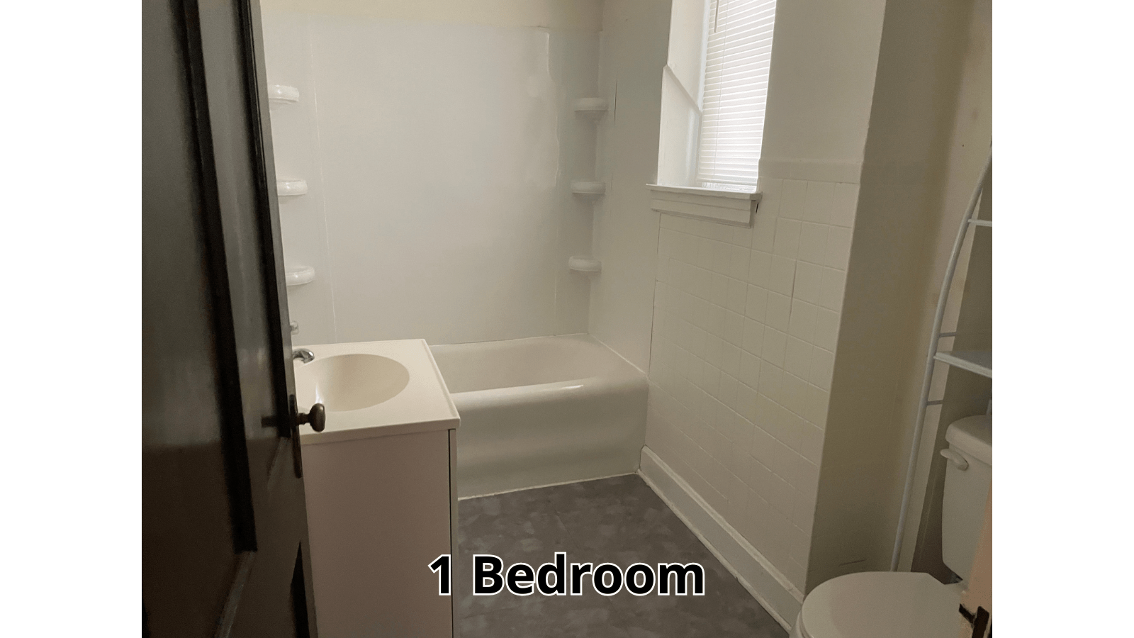 Bathroom with tub, vanity, and toilet