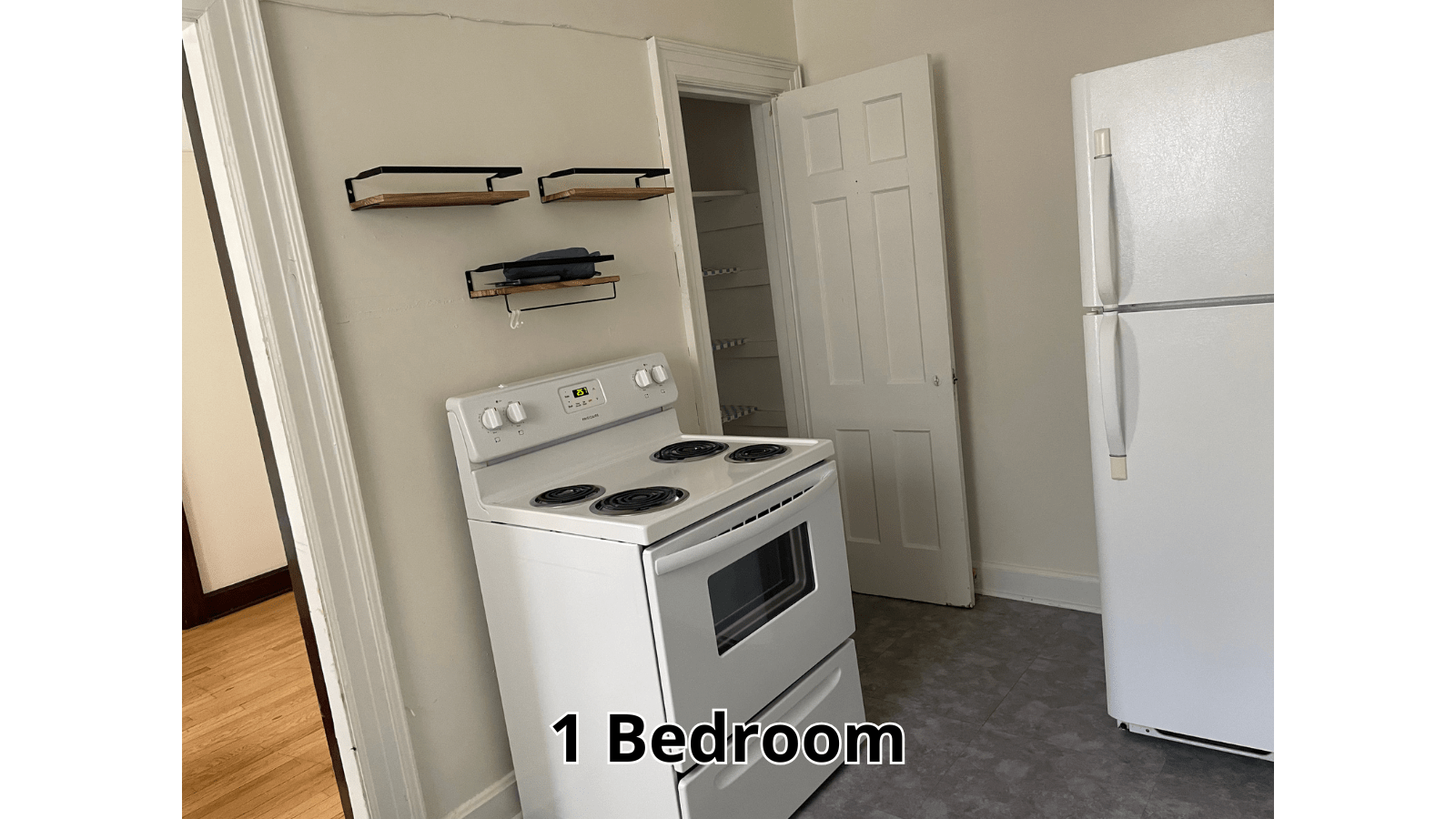 White kitchen with stove, fridge, and bedroom door