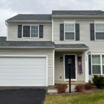 a two story house with white siding and black shutters