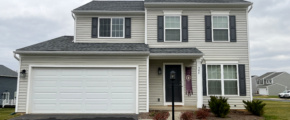 a two story house with white siding and black shutters