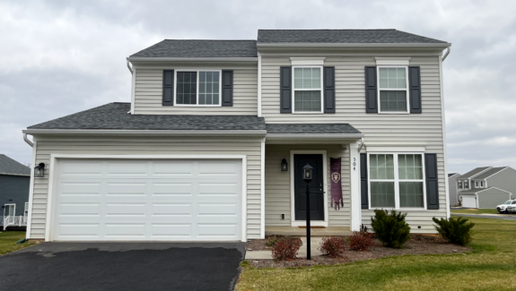 a two story house with white siding and black shutters