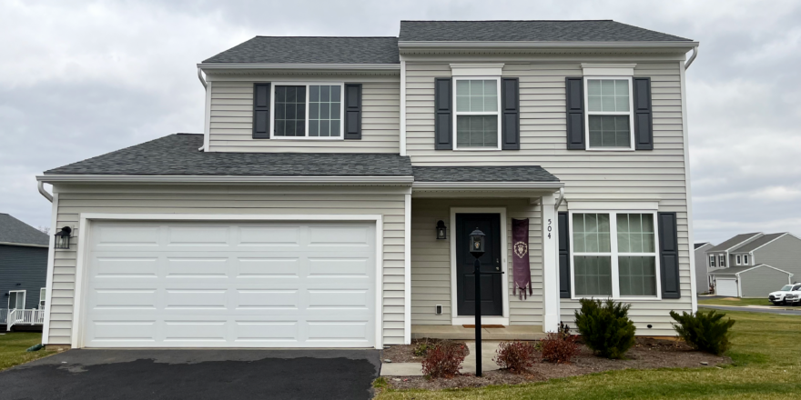 a two story house with white siding and black shutters