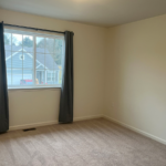 an empty room with a window and curtains