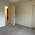 an empty room with two doors and carpet