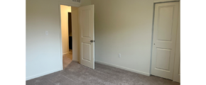 an empty room with two doors and carpet