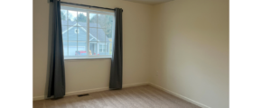 an empty room with a window and curtains
