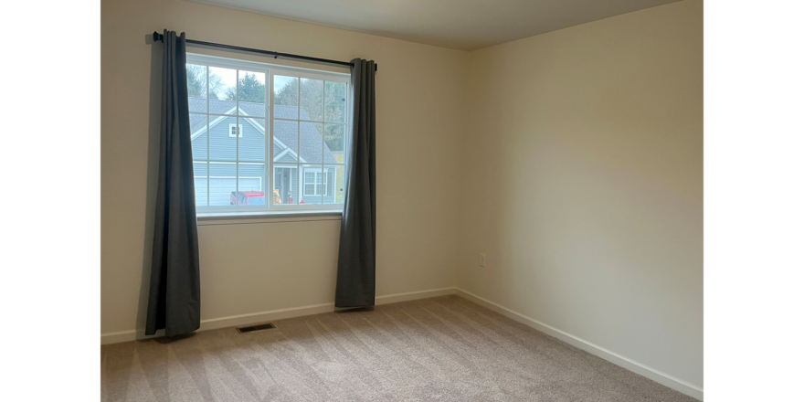 an empty room with a window and curtains