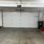 a white garage with two red buckets in it