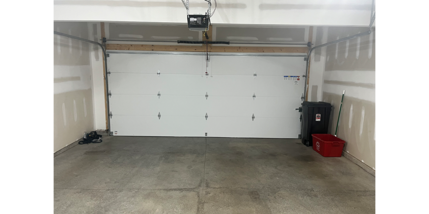 a white garage with two red buckets in it