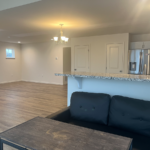 an empty living room and kitchen in a new home