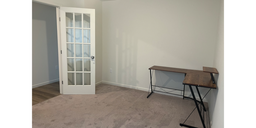 an empty room with a table and a door