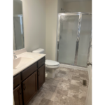 a bathroom with a shower, toilet and sink