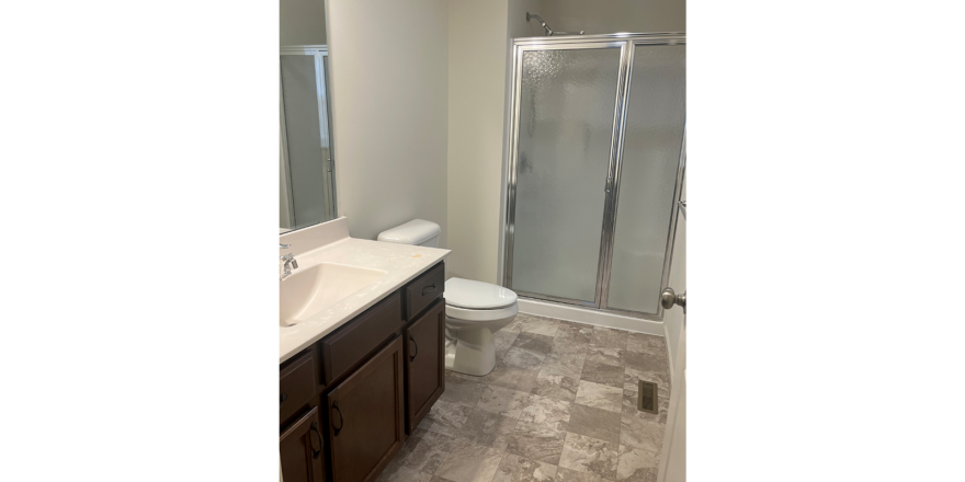 a bathroom with a shower, toilet and sink