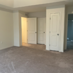 an empty room with white doors and carpet