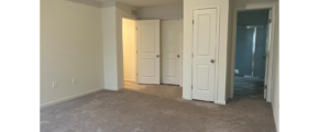 an empty room with white doors and carpet