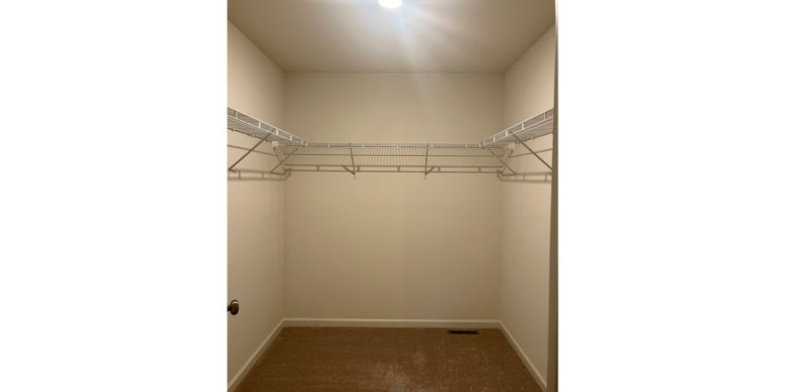 an empty closet with a light on the ceiling