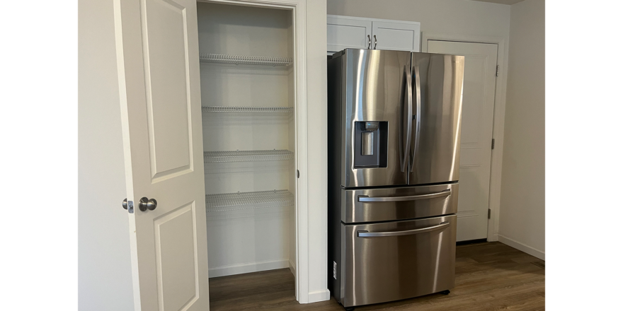 a stainless steel refrigerator in a white kitchen