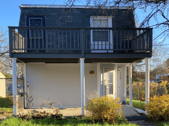 a small house with a balcony on the second floor