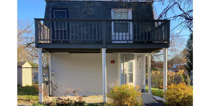 a small house with a balcony on the second floor