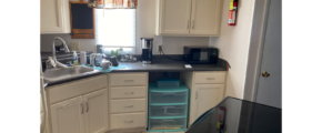 a kitchen with white cabinets and black counter tops