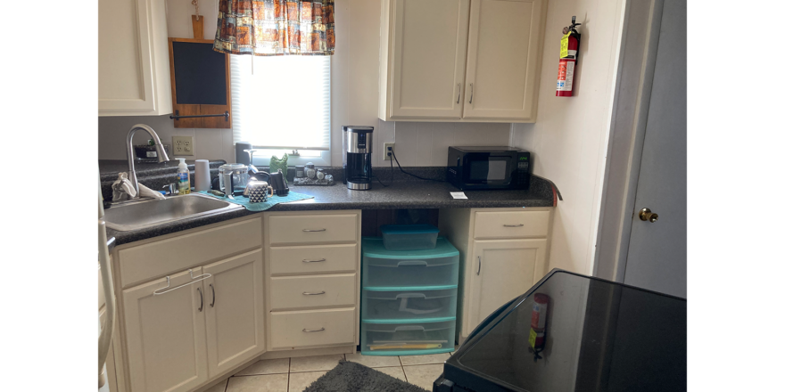 a kitchen with white cabinets and black counter tops