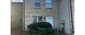 a brick building with a white door and three windows